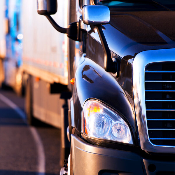 Primer plano de un camión en carretera, destacando la gestión de flotillas y la eficiencia operativa en el transporte comercial.